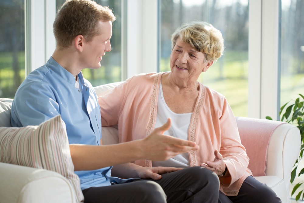 Male nurse and senior woman sitting on the couch.jpeg